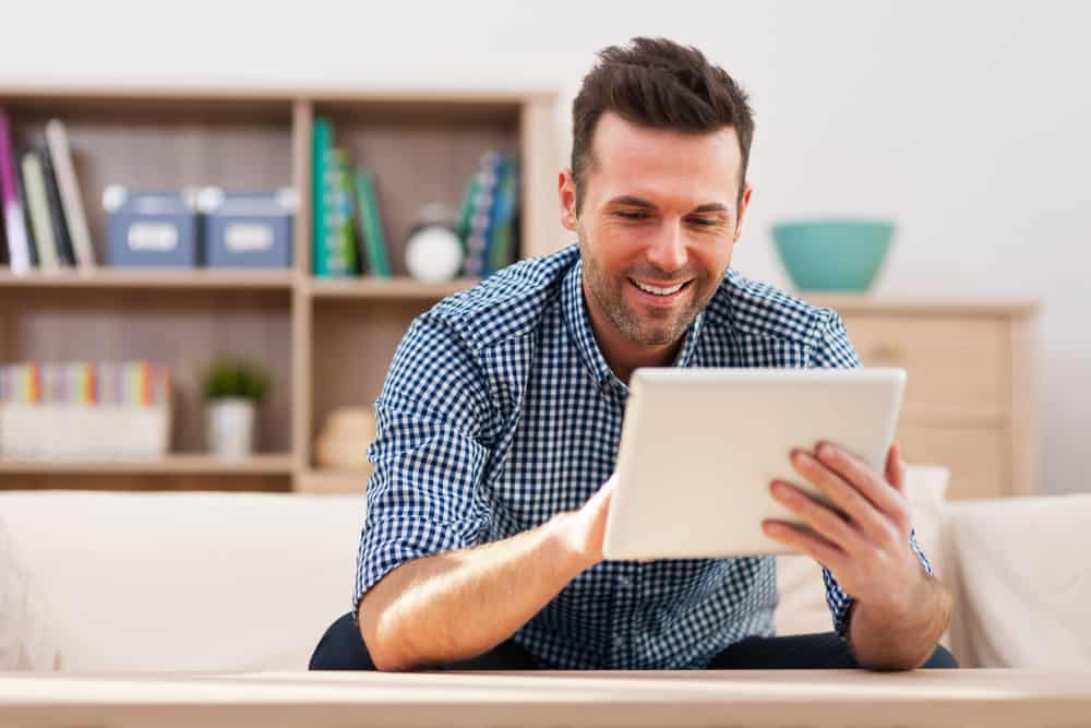 smiling-handsome-man-using-digital-tablet-home